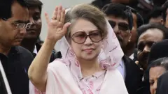 خالده ضیا با شال صورتی کم‌رنگ و عینک آفتابی، در ماه اپریل ۲۰۱۵ دست تکان می‌دهد.