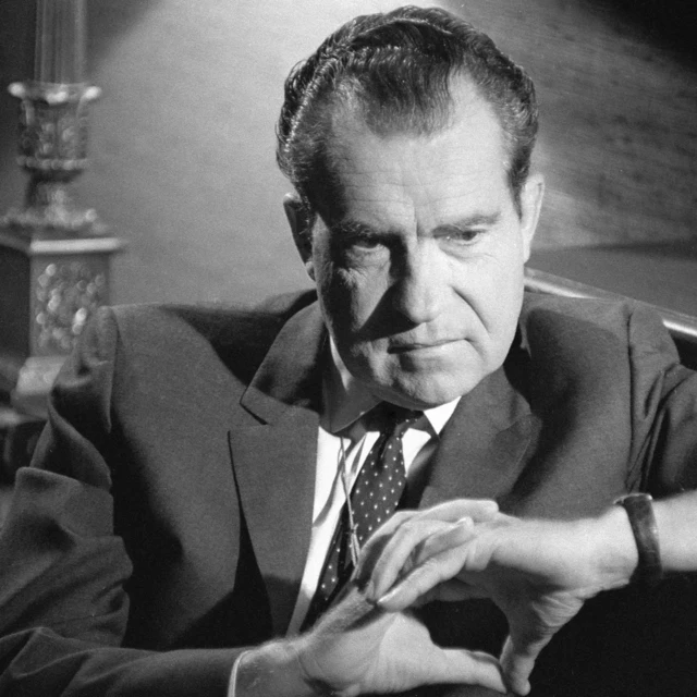 Eski ABD Başkanı Richard Nixon ellerini kavuşturmuş bir koltukta oturuyor