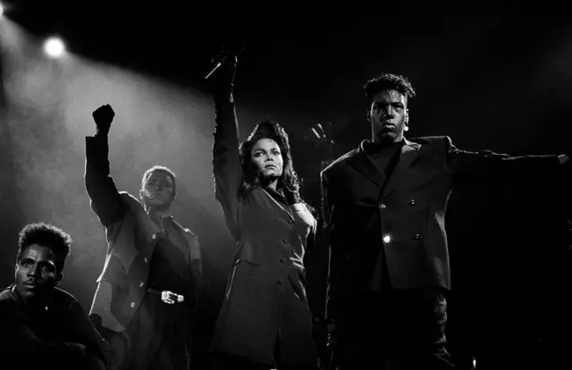 Janet Jackson pose le poing en l'air pendant le Rhythm Nation World Tour de 1990.