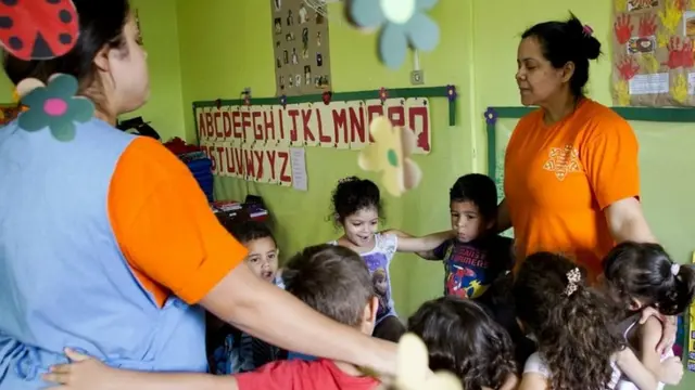 Roda de crianças e funcionários da creche