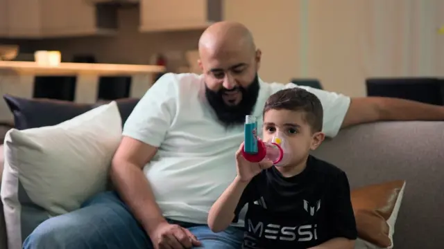 Jassem est assis à côté de son père Abdulrahman Alameeri avec son inhalateur.