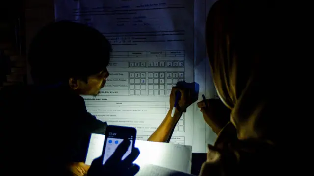Anggota KPPS warga Suku Badui menggunakan senter saat penghitungan suara di TPS 01 Desa Kanekes, Lebak, Banten, Rabu (27/11/2024). Penghitungan surat suara Pilkada gubernur-wakil gubernur Banten serta bupati-wakil bupati Kabupaten Lebak tersebut dilakukan warga Suku Badui dengan menggunakan senter karena tidak adanya aliran listrik di pemukiman Badui.
