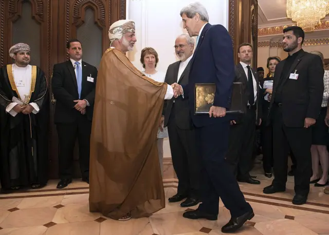 جان کری، وزیر خارجه وقت آمریکا (راست)، در ۹ نوامبر ۲۰۱۴ در مسقط با یوسف بن علوی، وزیر امور خارجه عمان، دست میدهد؛ در حالی که کاترین اشتون، مسئول پیشین سیاست خارجی اتحادیه اروپا (نفر دوم از چپ)، و محمدجواد ظریف، وزیر خارجه ایران، نظارهگر هستند.