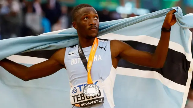 Letsile Tebogo riƙe da tutar Botswana yayin ya yake murnar lashe lambar yabo ta azurfa a gasar tsere ta duniya