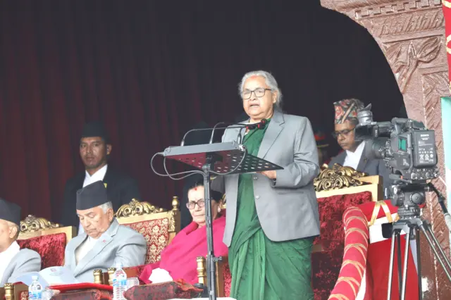प्रधानमन्त्री सुशीला कार्की सैनिक मञ्चबाट भाषण गर्दै, छेउमा राष्ट्रपति रामचन्द्र पौडेल बसेका छन्