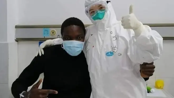 Cameroon student wey recover from coronavirus for China Kem Senou Pavel Daryl and health worker pose for foto
