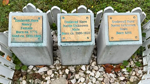 Three "stumbling stones" dedicated to enslaved individuals in Arlington, Virginia. They read: Enslaved Here, Nancy, Female, Born ca 1775, Died ca 1831-1840. Enslaved Here, Name Unknown, Male, Born ca 1806-1820. Enslaved Here, Name Unknown, Male, Born 1844 (Credit: Barbara Noe Kennedy)
