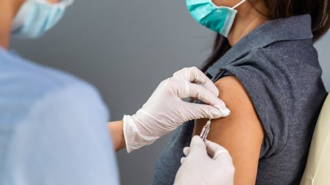 a nurse injecting a patient with a vaccine