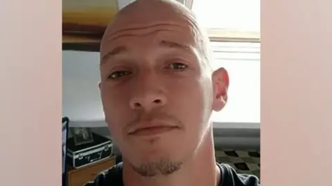 West Yorkshire Police A picture of Daniel Backhouse-Dyson who died after falling of his motorcycle. He is wearing a dark t-shirt and has a short goatee beard and a shaved head