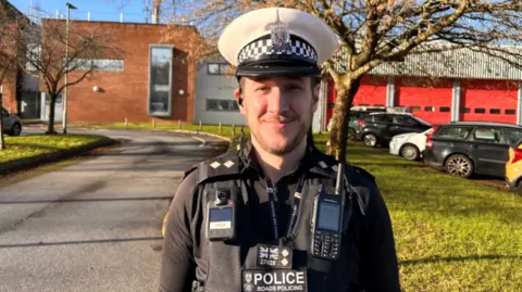 Inspector Chris Sharland smiling at the camera in his road policing uniform.