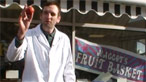 Maggot dressed in a white grocer's coat, holding a tomato