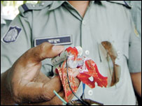 एक पुलिसकर्मी देसी बम दिखाते हुए