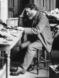 Black-and-white photo from 1895 showing Solomon Schechter sitting reading the Cairo Geniza manuscripts