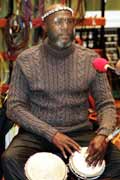 A Rastafarian man drumming at a reasoning session