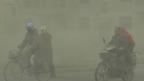 甘肅西部玉門市民眾在強勁沙塵暴中騎乘自乘車與摩托車出行（中新社圖片28/2/2013）