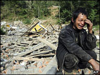 Homem chora diante de escombros deixados pelo terremoto que atingiu Sichuán, na China