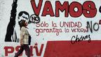 Mulher caminha em frente a muro com propaganda do referendo em 2009