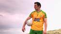 Caoimhín Ó Caiside wearing County Donegal kit on the beach.